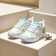 Girls’ Santorini Travel Sneakers in white with floral design on a sunny background.